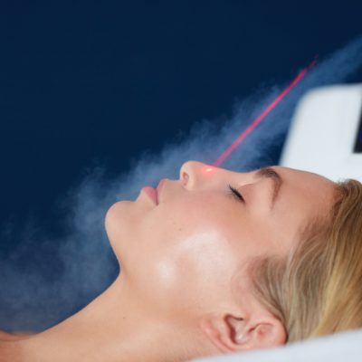 Localized cryotherapy session on the face of young woman. Treatment uses vaporized nitrogen to lower the skin temperature.
