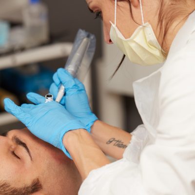 professional tattooist making permanent make up tricopigmentation